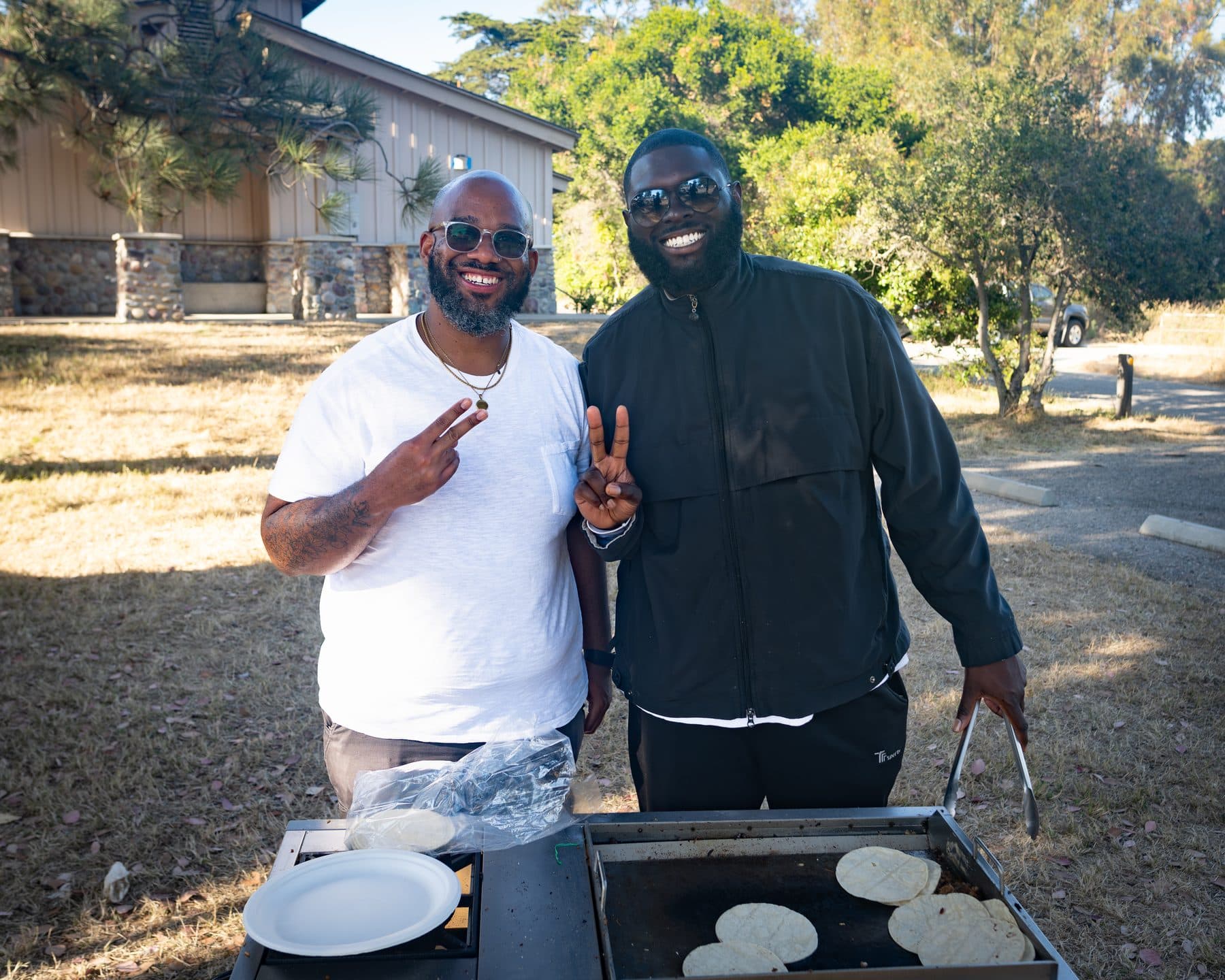 Two camp cooks flipping pancakes on the griddle at the El Capitan camp kitchen